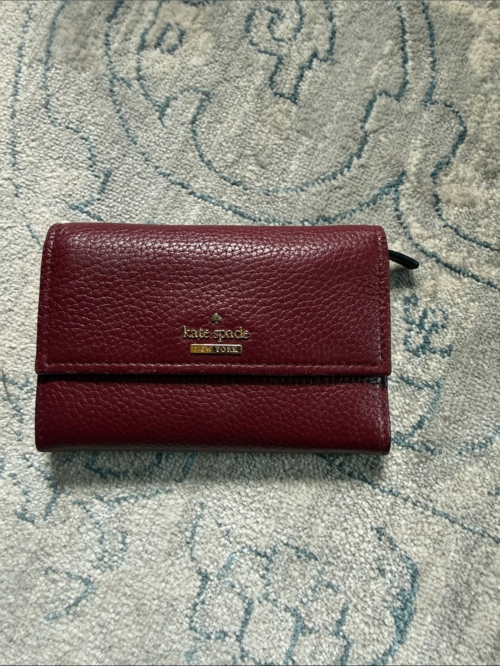 kate spade Pebbled Leather Trifold Wallet in Burgundy